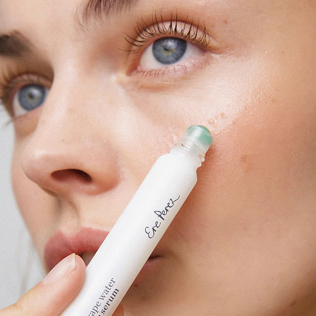 Person applying Ere Perez eye serum to their eye area